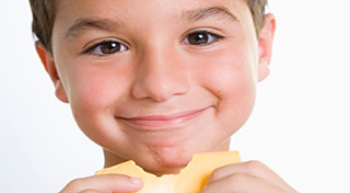 boy snacking on a piece of cheese